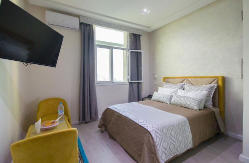a bedroom with a bed and a flat screen tv at Mamora Bay in Tangier
