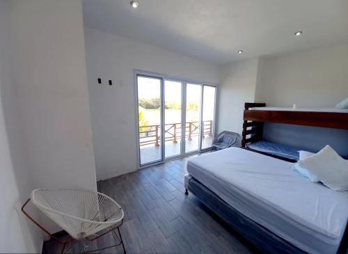 Un dormitorio con una cama y un balcón. en Las Villas Taxisco, en Taxisco