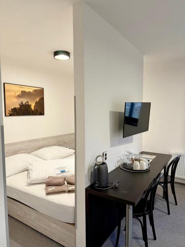 a bedroom with a bed and a desk and a table with chairs at Resort Mezná in Hřensko
