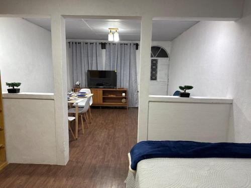 科万Apartamento en Cobán casa Azul的一间带床的卧室和一间带桌子的餐厅