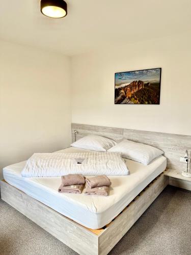 a bedroom with a large white bed with a wooden frame at Resort Mezná in Hřensko