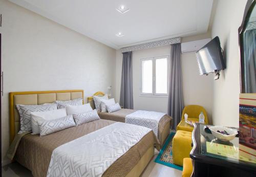 a hotel room with two beds and a television at Mamora Bay in Tangier