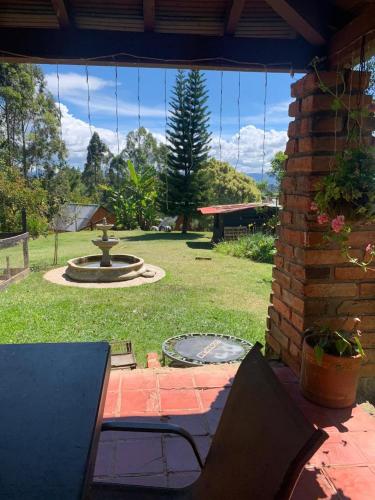 a patio with a table and chairs and a fountain at Encanto Verde cabaña sencilla in Marinilla