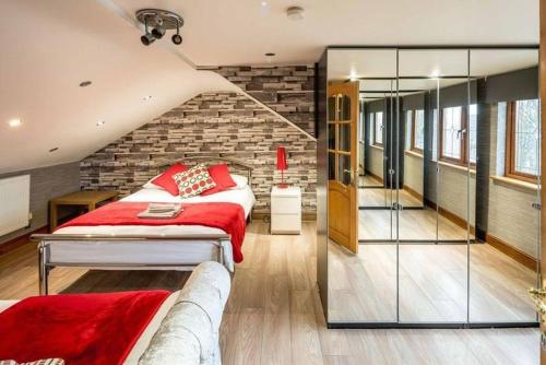 a bedroom with a red bed and a brick wall at Huge 6 Beds House in Zone 2 London-MobileRateOffers-Families-Leisure-Parking-WiFi-PoolTable-Netflix-Sleeps15! in London