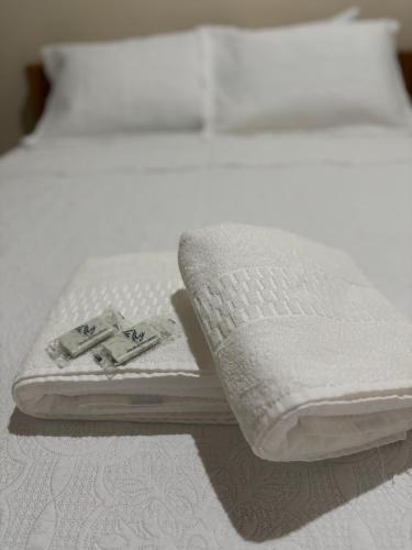 a white bed with two folded towels on it at POUSADA LAR DA JOSÉFA in Estivado
