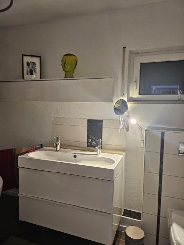 a bathroom with a white sink and a window at Ferienwohnung AM HOCHBERG in Bad Kissingen