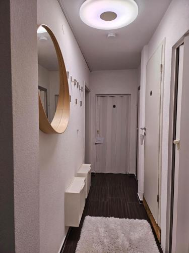 a hallway with a mirror on the wall and a sink at Ferienwohnung AM HOCHBERG in Bad Kissingen