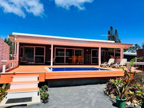 a house with a swimming pool on a deck at Te-Hirimoana Villa in Vaimaanga