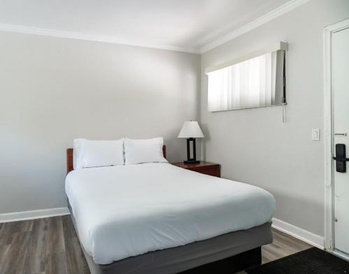 una camera da letto bianca con un letto bianco e una finestra di Comfortable Brownstown Stay – Queen Bed Private Bath a Woodhaven