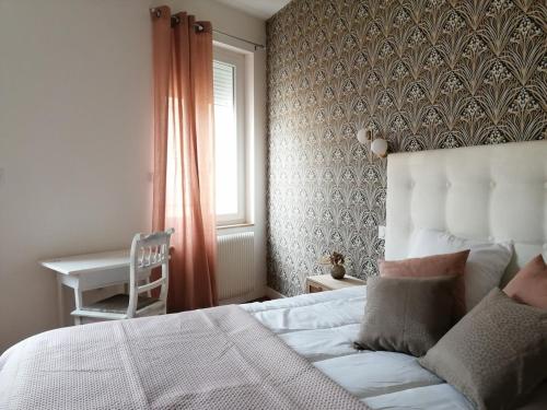 une chambre avec un lit, une fenêtre et une chaise dans l'établissement Appartement calme et raffiné, à Mâcon