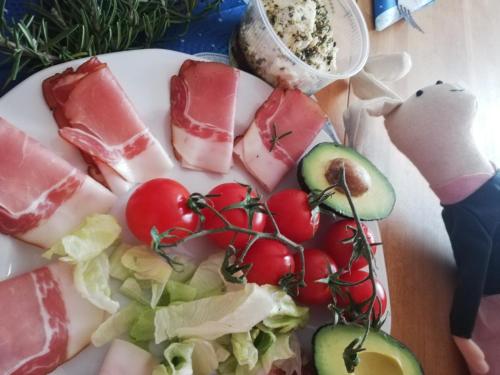 a plate of food with fruits and vegetables on a table at Sailor Apartman Balatonlelle in Balatonlelle