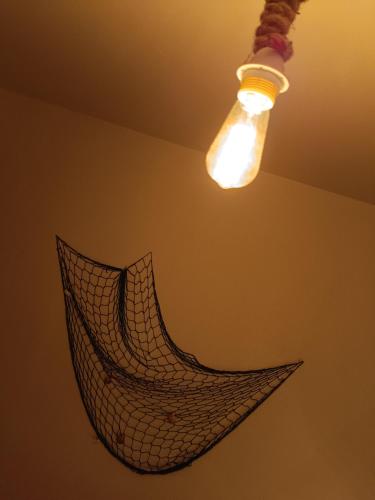a light bulb and a net hanging from a ceiling at Sailor Apartman Balatonlelle in Balatonlelle