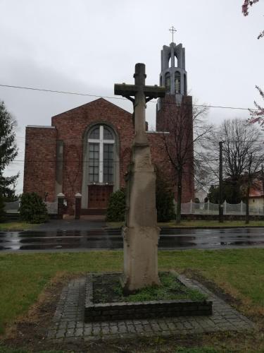 a cross in front of a building with a church at Sailor Apartman Balatonlelle in Balatonlelle