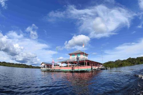 a house boat on the water on a lake at Evolução Ecolodge in Iranduba