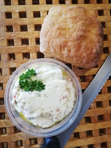 a bowl of coleslaw next to a loaf of bread at Sailor Apartman Balatonlelle in Balatonlelle