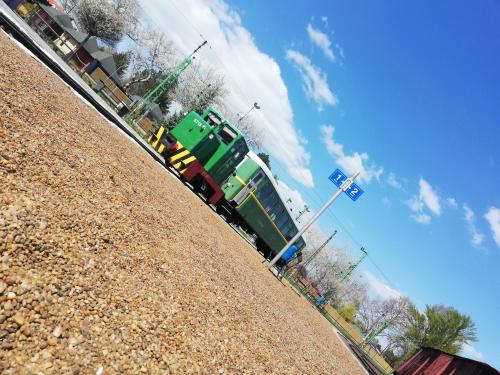 a train is on the tracks next to a hill at Sailor Apartman Balatonlelle in Balatonlelle