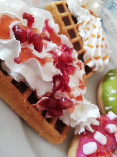 two waffles with toppings on a plate with an apple at Sailor Apartman Balatonlelle in Balatonlelle