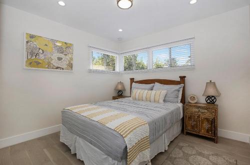 a bedroom with a bed and two windows at Oasis with pool and music studio by BENVENU in Los Angeles