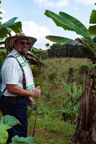 a man wearing a hat standing in a field at Hotel Cacaobetulia in Maceo