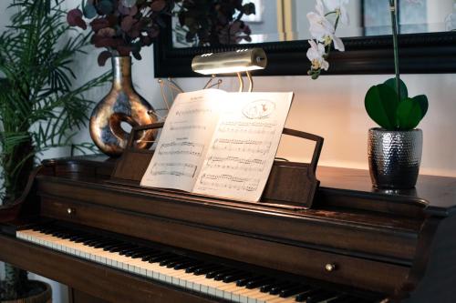 a piano with a sheet music on top of it at Oasis with pool and music studio by BENVENU in Los Angeles