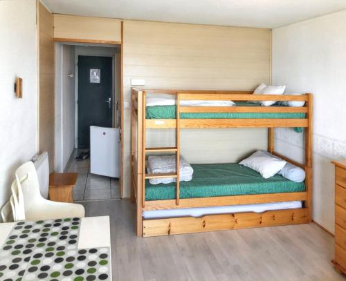 Cette chambre comprend 2 lits superposés et une table. dans l'établissement Appartement confortable au Corbier de 22 m² avec balcon, au Corbier