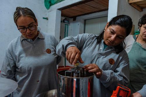 a woman is standing next to a man using a blender at Hotel Cacaobetulia in Maceo