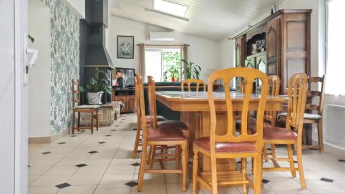 une salle à manger avec une table et des chaises dans l'établissement Maison spacieuse à Venansault avec jardin et terrasse, à Venansault