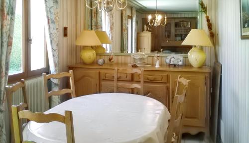 une salle à manger avec une table et un miroir dans l'établissement Maison confortable à Le Mans avec jardin et terrasse, au Mans