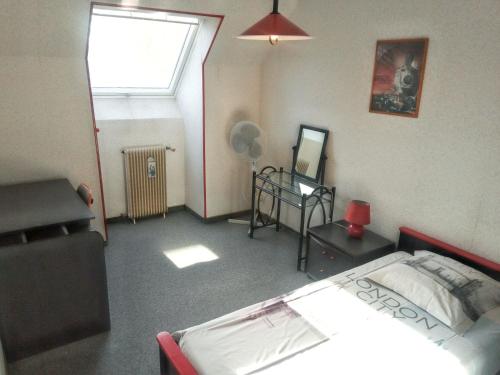 une petite pièce avec un lit et une fenêtre dans l'établissement Maison confortable à Le Mans avec jardin et terrasse, au Mans