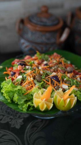a salad on a green plate on a table at Evolução Ecolodge in Iranduba