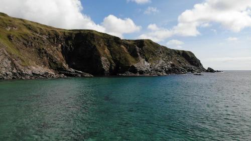 a large body of water next to a rocky mountain at The Limehouse Cottage in Killybegs
