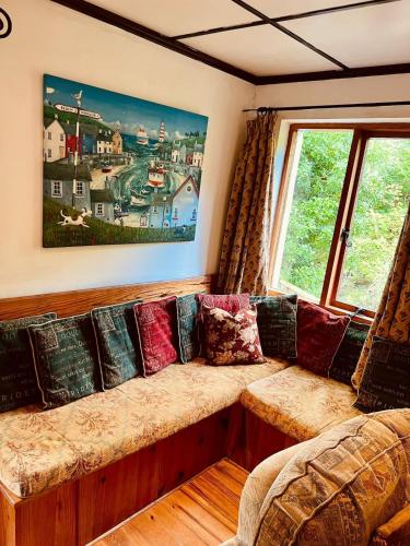a couch in a living room with a window at The Limehouse Cottage in Killybegs