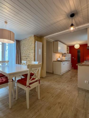 une salle à manger et une cuisine avec une table et des chaises dans l'établissement Timaë, à Ouistreham