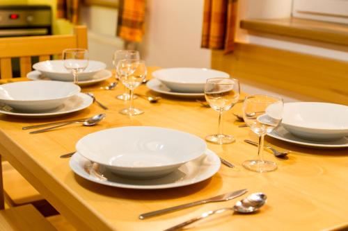 a wooden table with plates and wine glasses on it at Bedřichovská Devítka in Bedřichov
