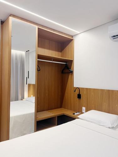 a small bedroom with two beds and a mirror at Apto Premium Resort in Salinópolis