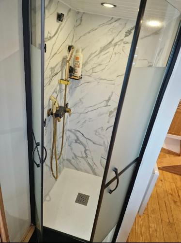 une cabine de douche avec un mur en marbre dans l'établissement Calaidonia boat house, à Calais