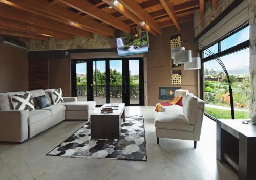 a living room with two couches and a tv at Parra del Valle Hotel Boutique in Valle de Guadalupe