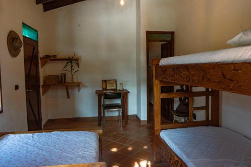 a room with two bunk beds and a table at Hotel Cacaobetulia in Maceo