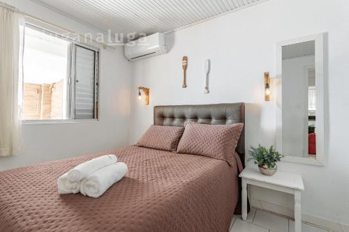 a bedroom with a bed with a towel on it at Casa pé na areia SC - Espaço completo in Guaporanga