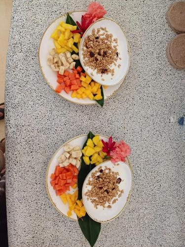 zwei Teller Essen auf einem Tisch mit Blumen darauf in der Unterkunft Las Nubes Natural Energy Resort in Savegre