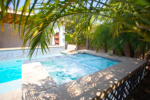 a swimming pool with a palm tree in front of a building at Oasis with pool and music studio by BENVENU in Los Angeles