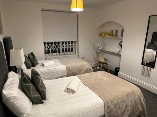une chambre d'hôtel avec deux lits et une chaise dans l'établissement Mornington Crescent Suites, à Londres