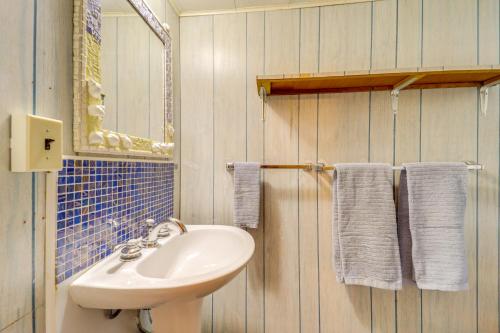 a bathroom with a sink and a mirror and towels at Waterfront Alanson Cottage with Dock and Lake Access! in Alanson