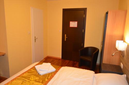 a bedroom with a bed and a chair and a door at Beausite in Lausanne