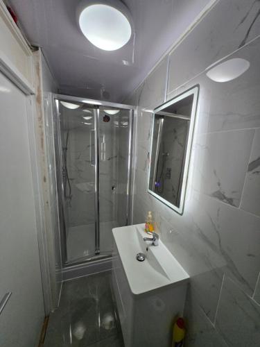 a bathroom with a shower and a sink and a mirror at SnoozeDen Chalvey - Free Parking, Near M4 J6 in Slough