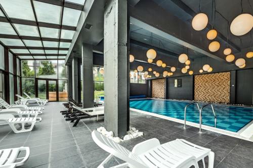 una piscina con sedie a sdraio bianche e una piscina di South Mountain Apartment a Razlog