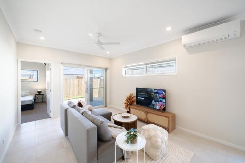 a living room with a couch and a tv at Bottlebrush Retreat - 4BR Home in Griffin in Griffin