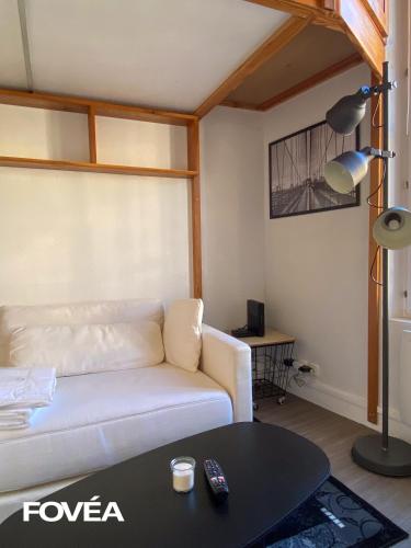 un salon avec un canapé blanc et une table dans l'établissement Ares, à Caen