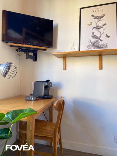 Elle comprend un bureau avec une chaise et une télévision murale. dans l'établissement Ares, à Caen