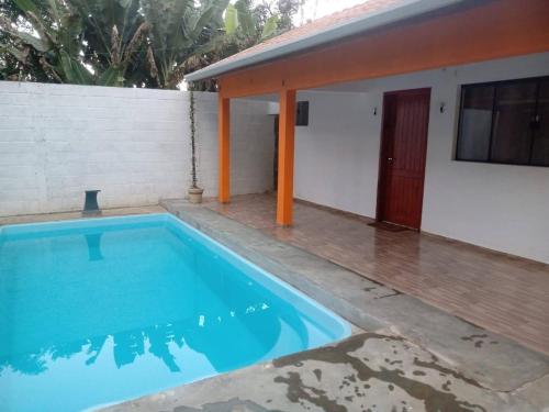 a swimming pool in front of a house at Chalé Primavera em Gonçalves in Gonçalves